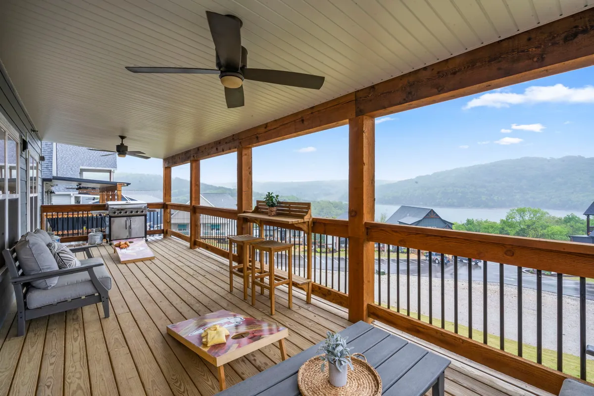 An inviting exterior patio scene with comfortable outdoor seating, a grill, and sweeping views of the surrounding landscape. The ambiance is relaxed and perfect for unwinding after a day exploring local attractions, with the potential for sunset views and group gatherings.